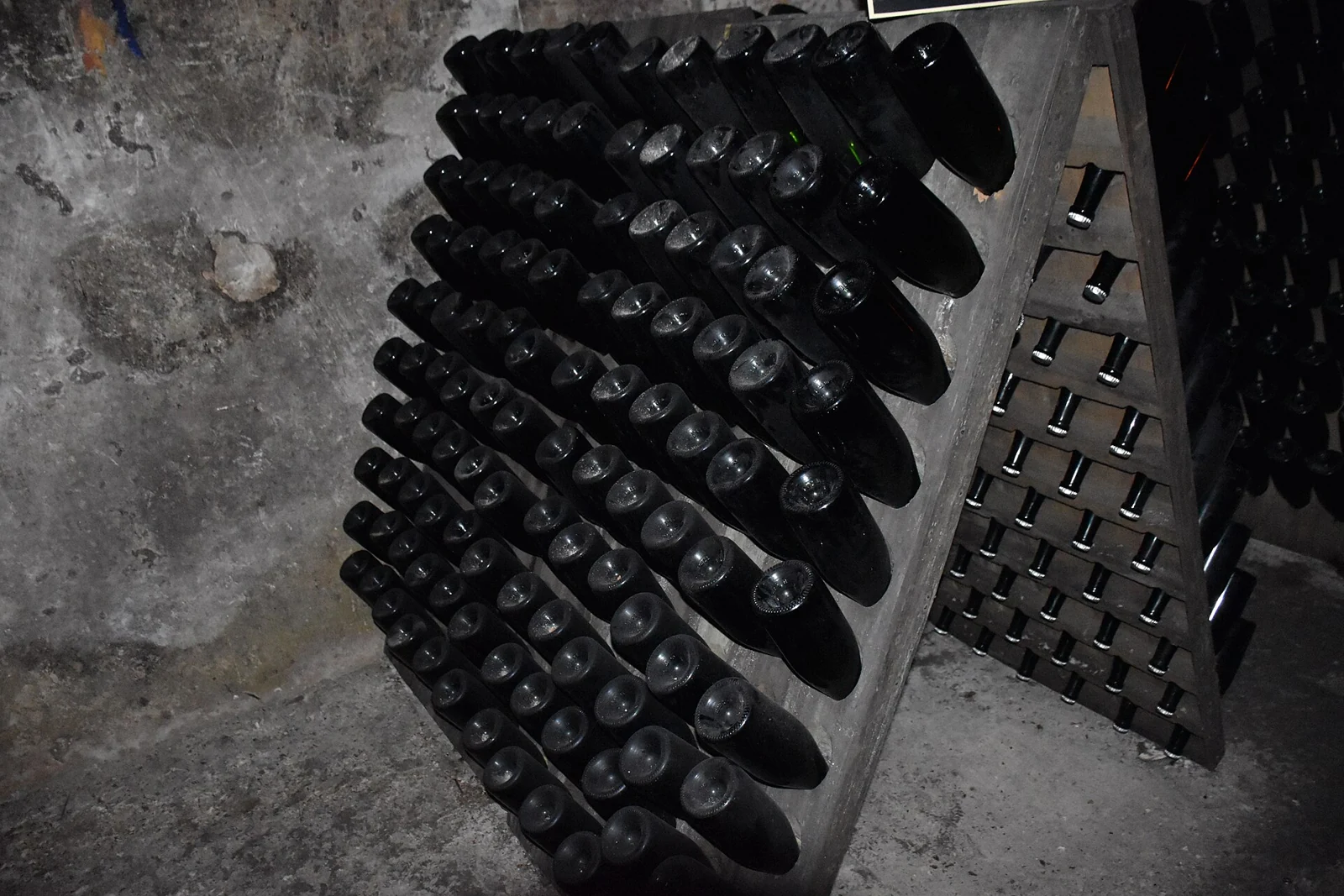 Champagne bottles held neck down in a wooden rack in Pommery’s cellars