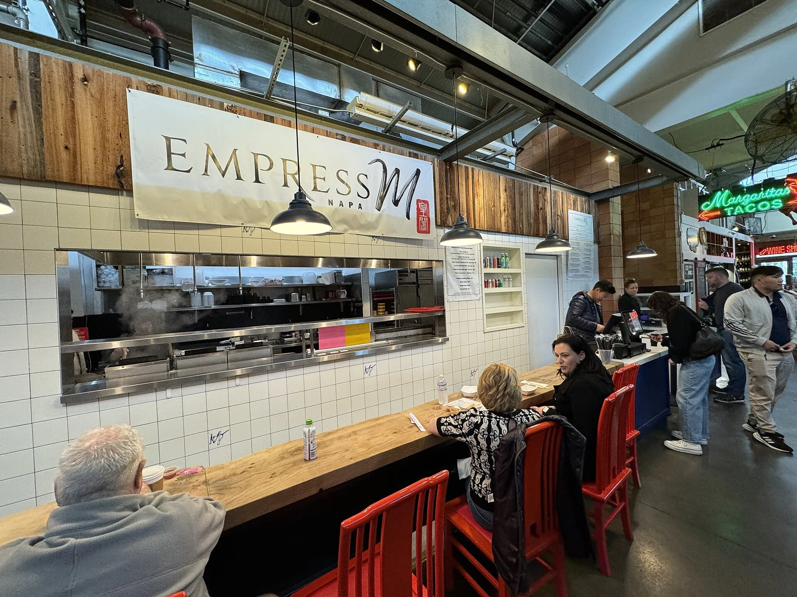 Visitors eating at the Empress M pop-up counter inside Oxbow Public Market