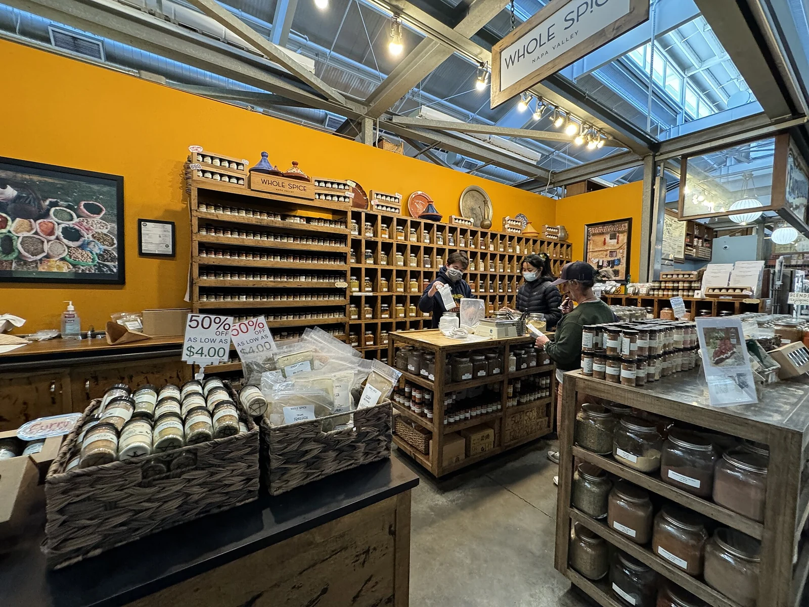 People browsing spices and food at Whole Spice inside Oxbow Public Market
